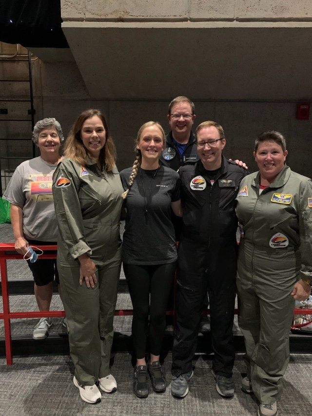 Group of peopl in flight suits smiling together 